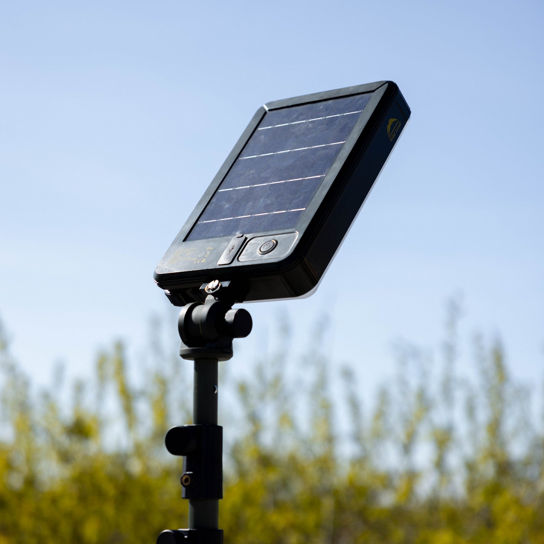 Solar-powered light on a stand with a blurred natural background